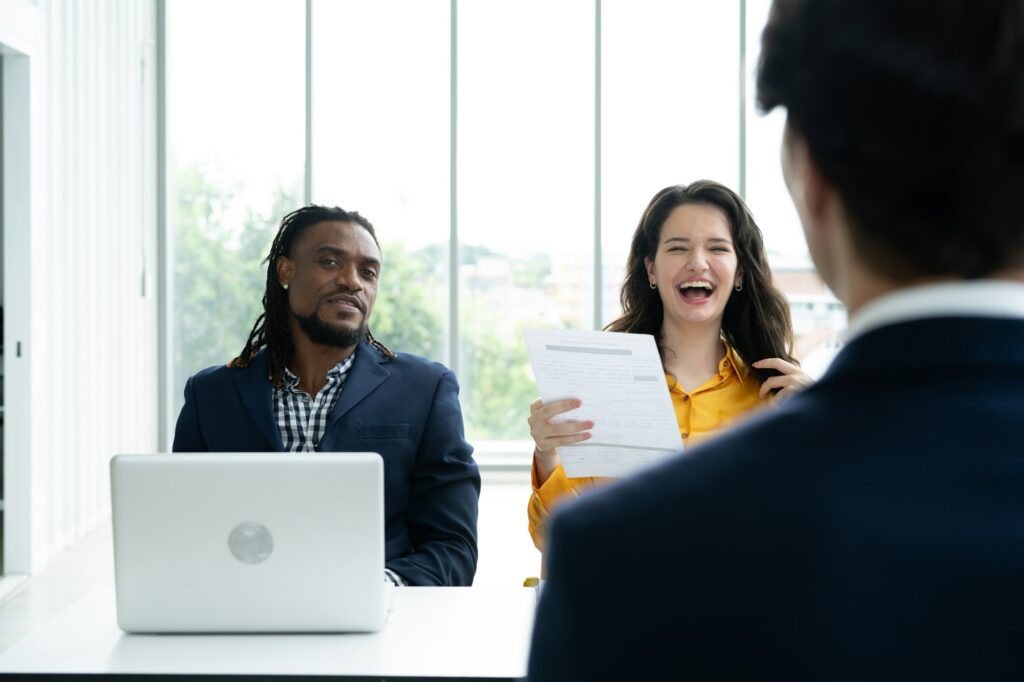 Job interview concept. Diverse hr team doing job interview with a man in business office. Happy